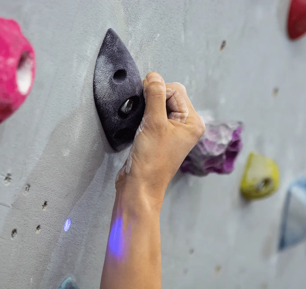Mano agarrando una presa con el LED azul de Nimbus encendido debajo